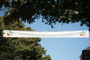 Bild von Banner des Landes-Musik-Festivals vor blauem Himmel und Bäumen